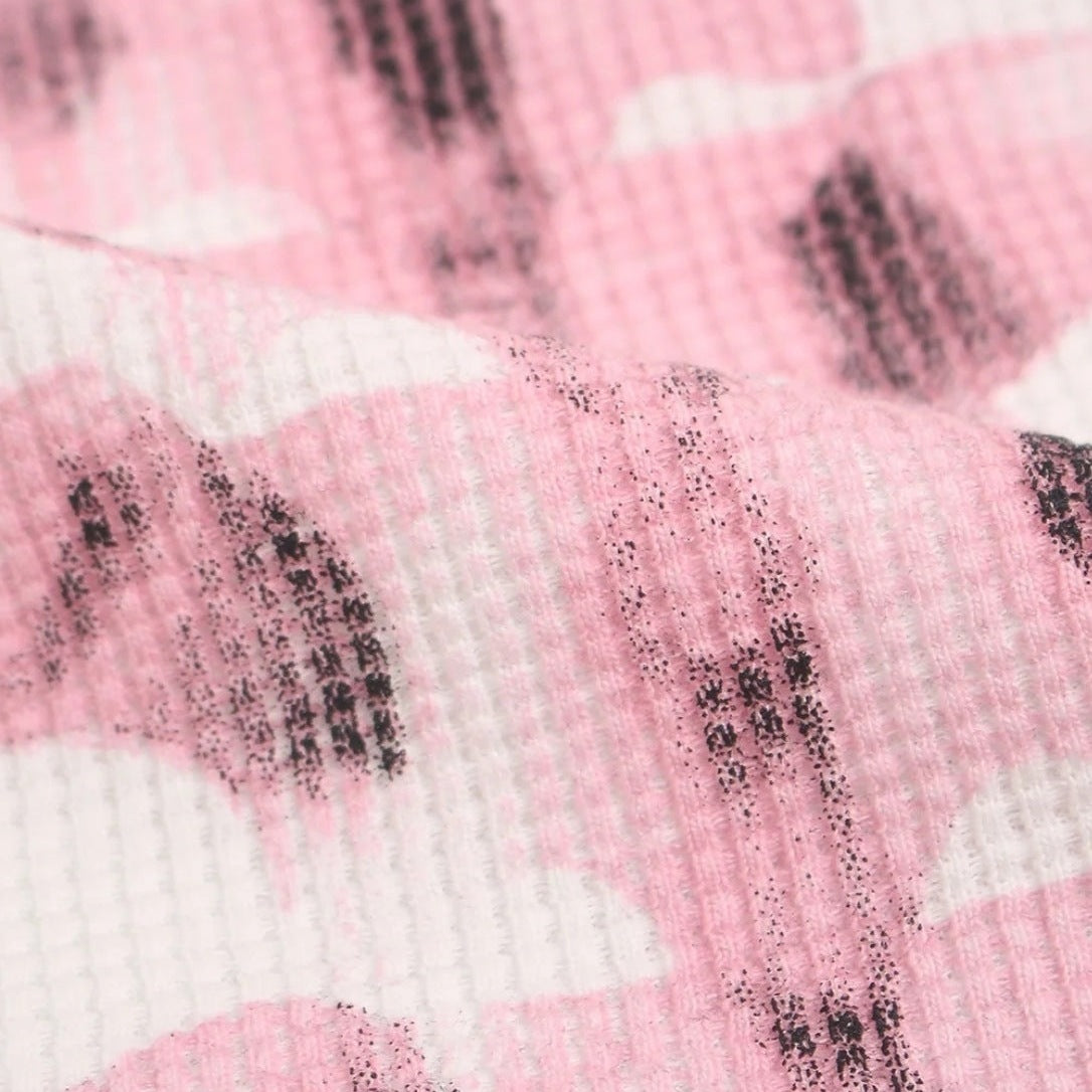 Close-up van roze wafelstructuur stof met abstract ribbenkast printpatroon | Boutique Moda
