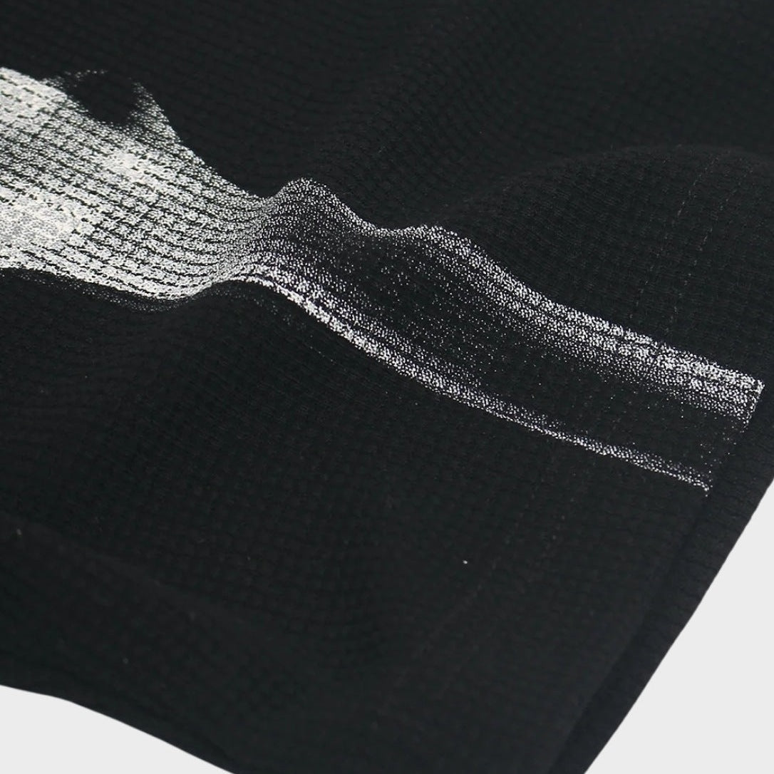 Close-up van zwart wafelstructuur shirt met zilverkleurige ribbenkast print, platliggend getoond | Boutique Moda