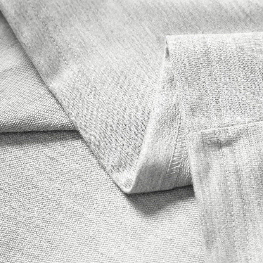 Lichtgrijze longsleeve met subtiele streep, close-up van stof en gevouwen mouw | Boutique Moda