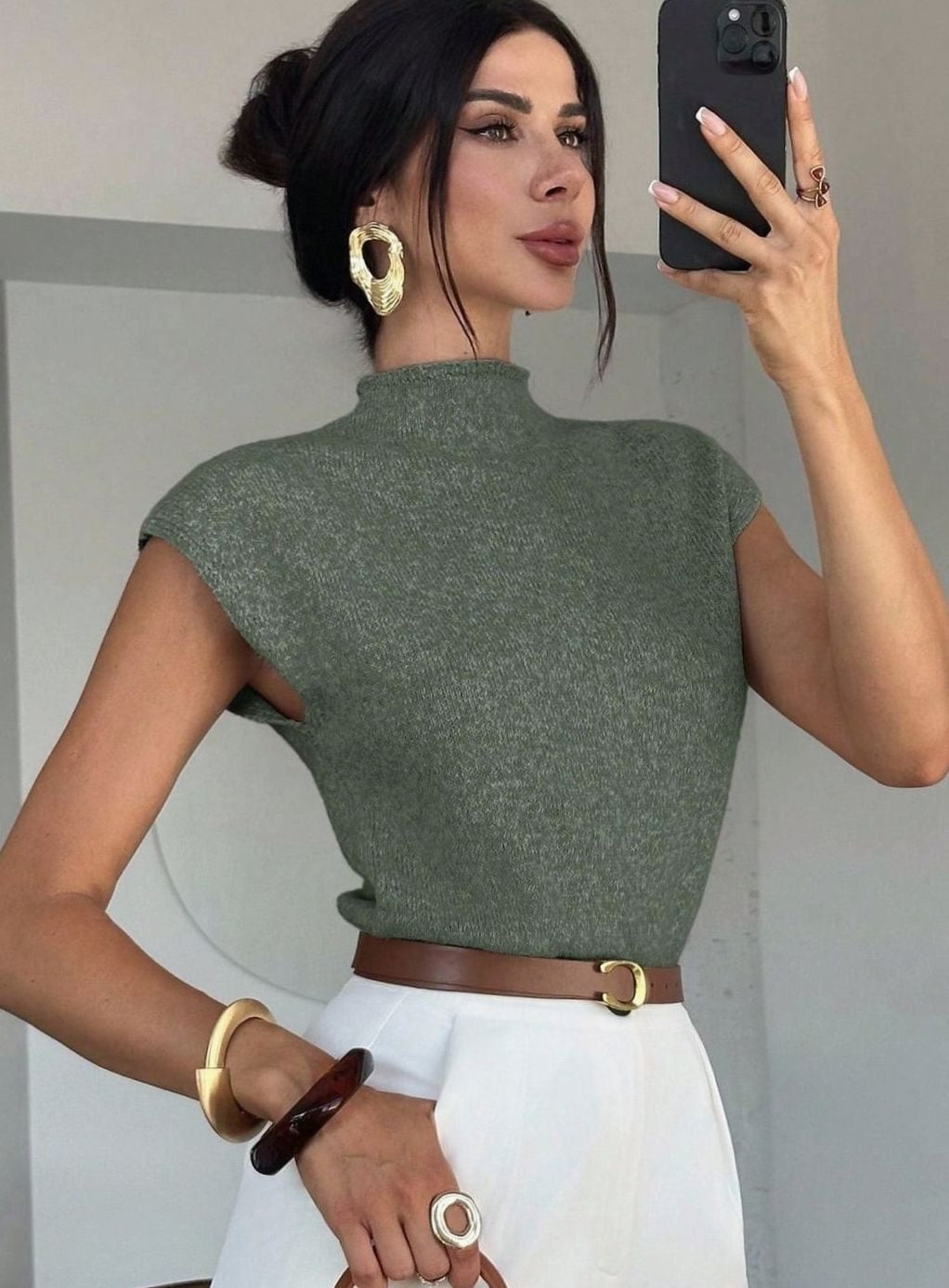 Olijfgroene spencer met opstaande col, gestyled met een bruine riem en gouden sieraden