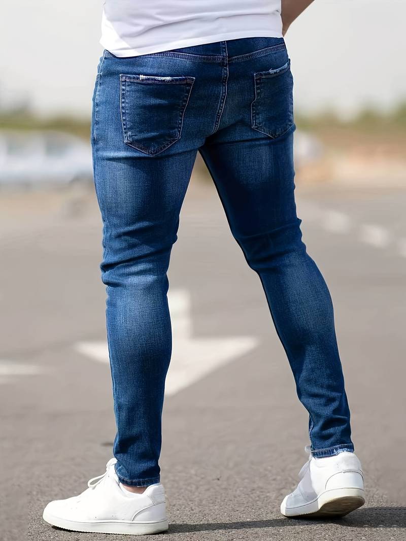 Indigoblauwe skinny spijkerbroek met scheuren gedragen