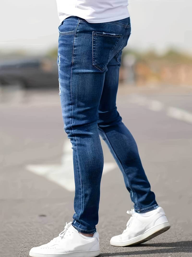 Indigoblauwe skinny spijkerbroek met scheuren gedragen