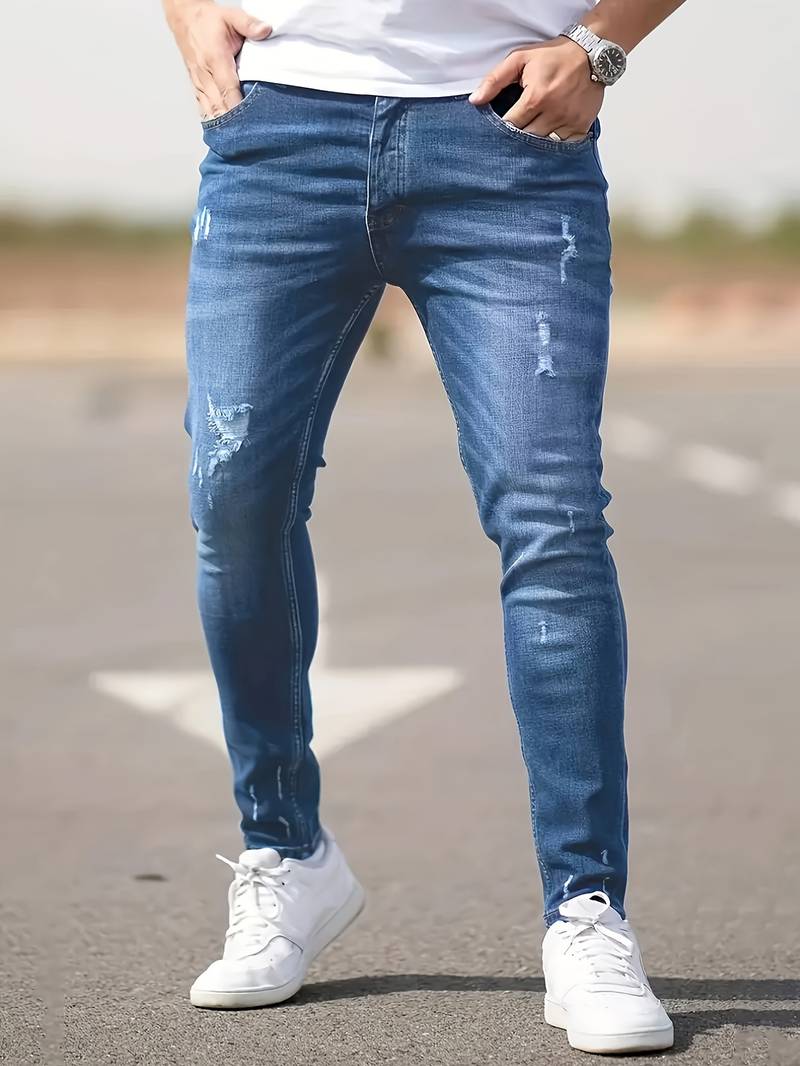 Middenblauwe skinny spijkerbroek met scheuren gedragen