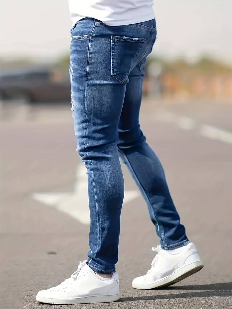 Middenblauwe skinny spijkerbroek met scheuren gedragen
