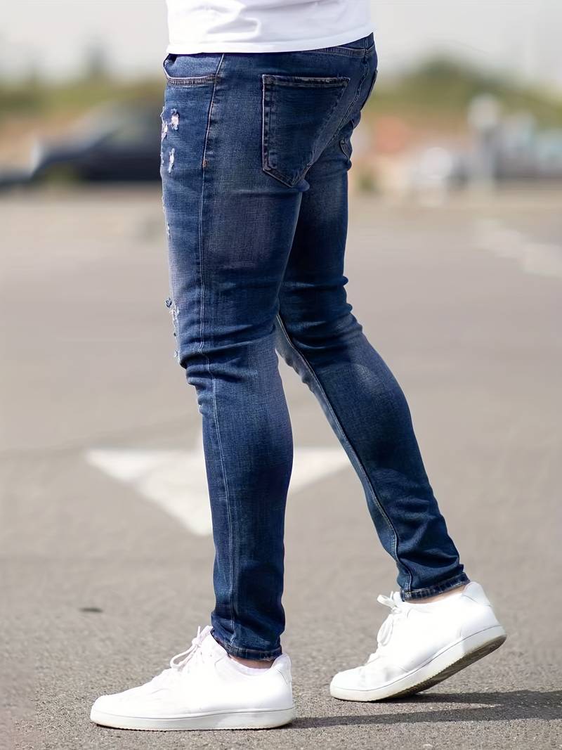 Donkerblauwe skinny spijkerbroek met scheuren gedragen