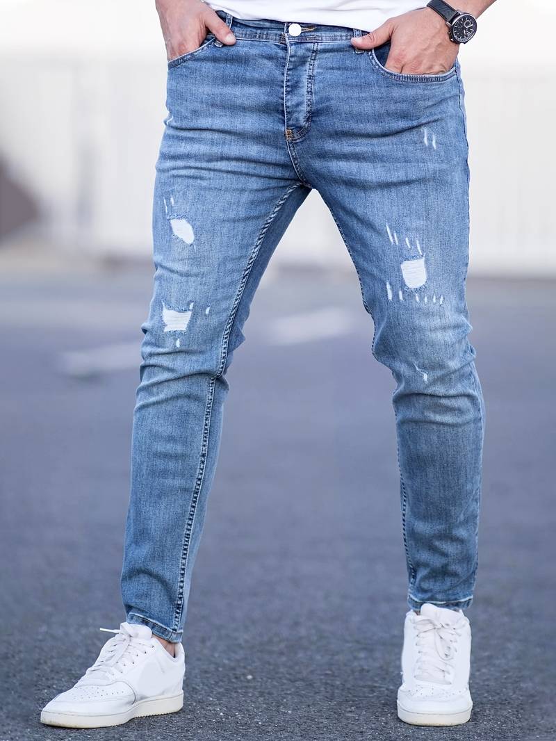Lichtblauwe skinny spijkerbroek met scheuren gedragen