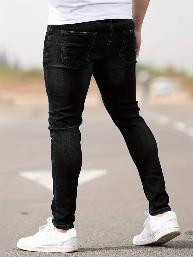 Grafietkleurige skinny spijkerbroek met scheuren gedragen