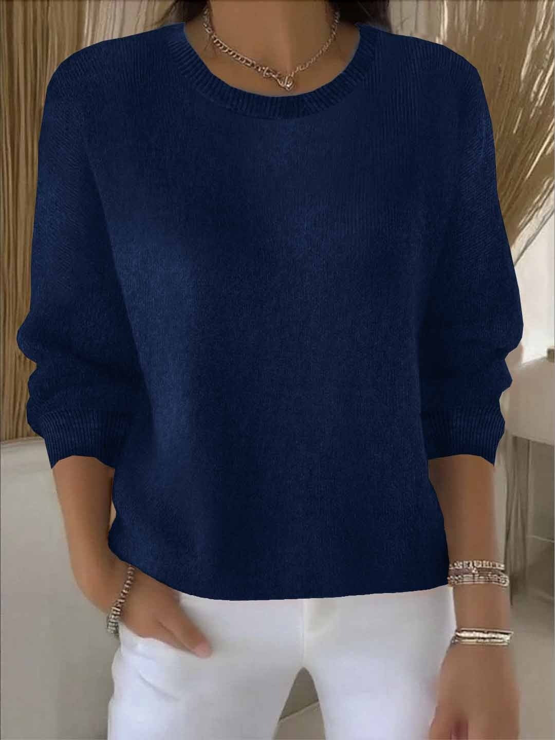 Fijngebreide oversized damestrui in marineblauw met ronde hals, gedragen op een witte broek
