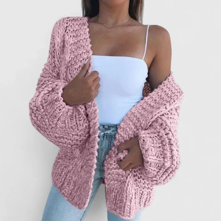 Grofgebreid oversized damesvest in roze, open gedragen over een wit topje