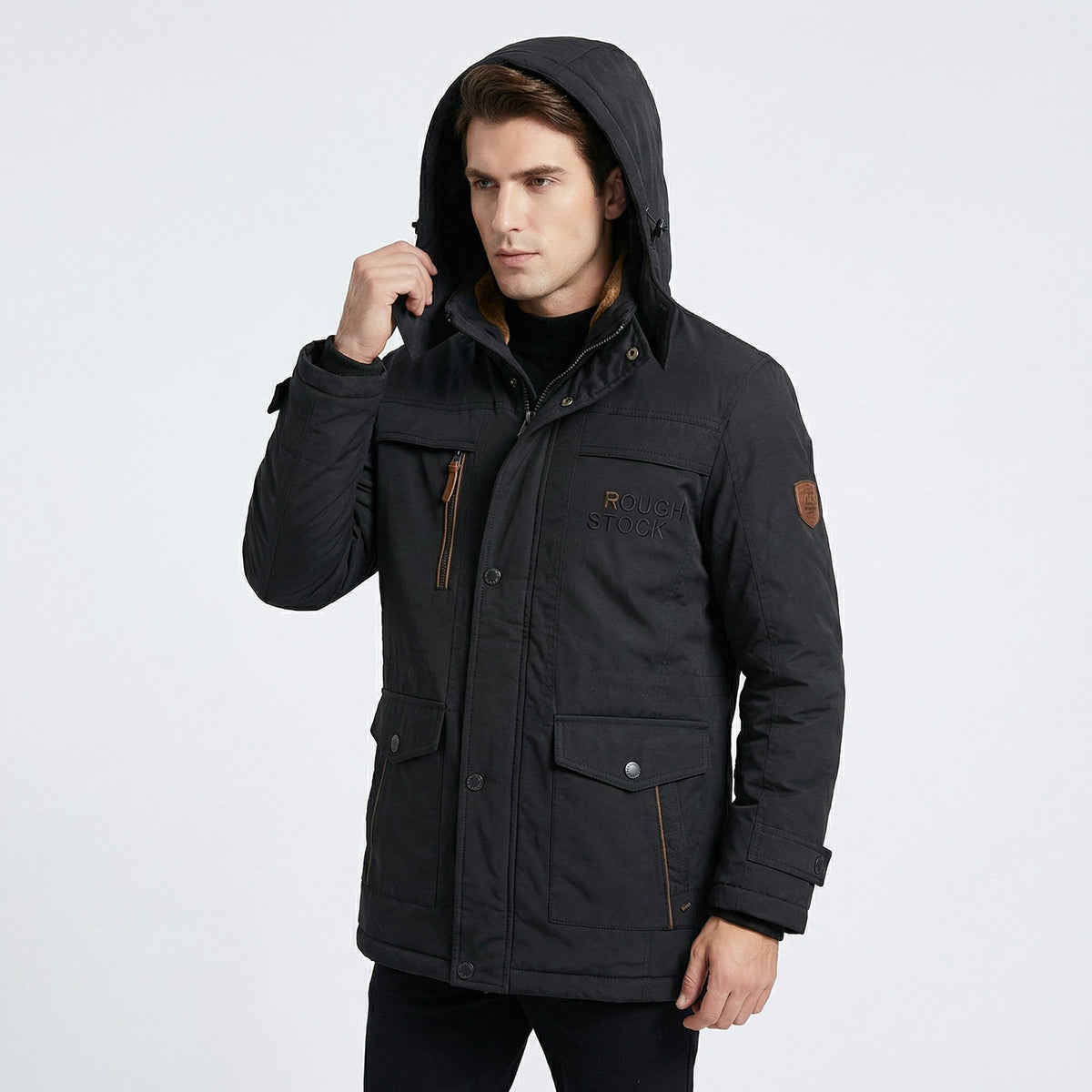 Man draagt zwarte winterparka met capuchon op, hand aan de kraag | Boutique Moda