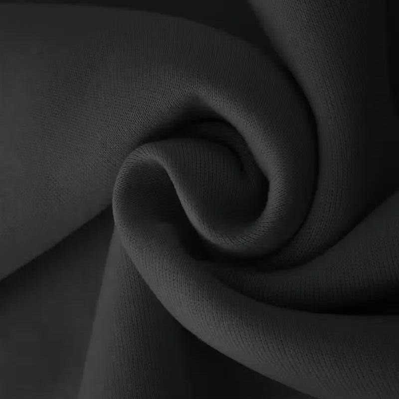 Zwarte stof close-up met gedraaide swirl textuur, geen persoon zichtbaar | Boutique Moda