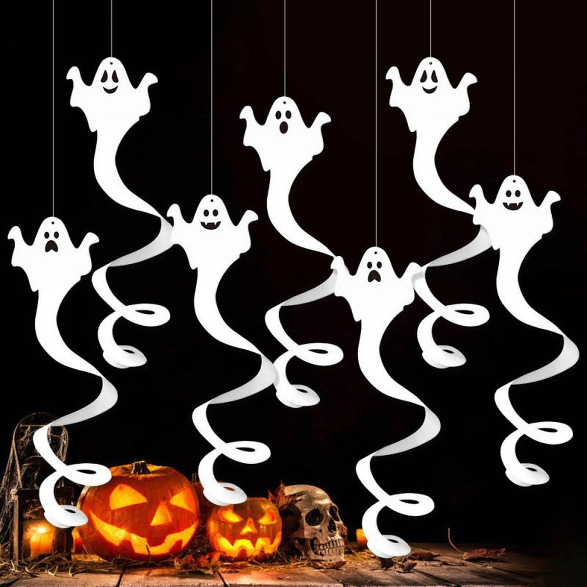 Hangende spookjes boven pompoenen als versiering voor Halloween