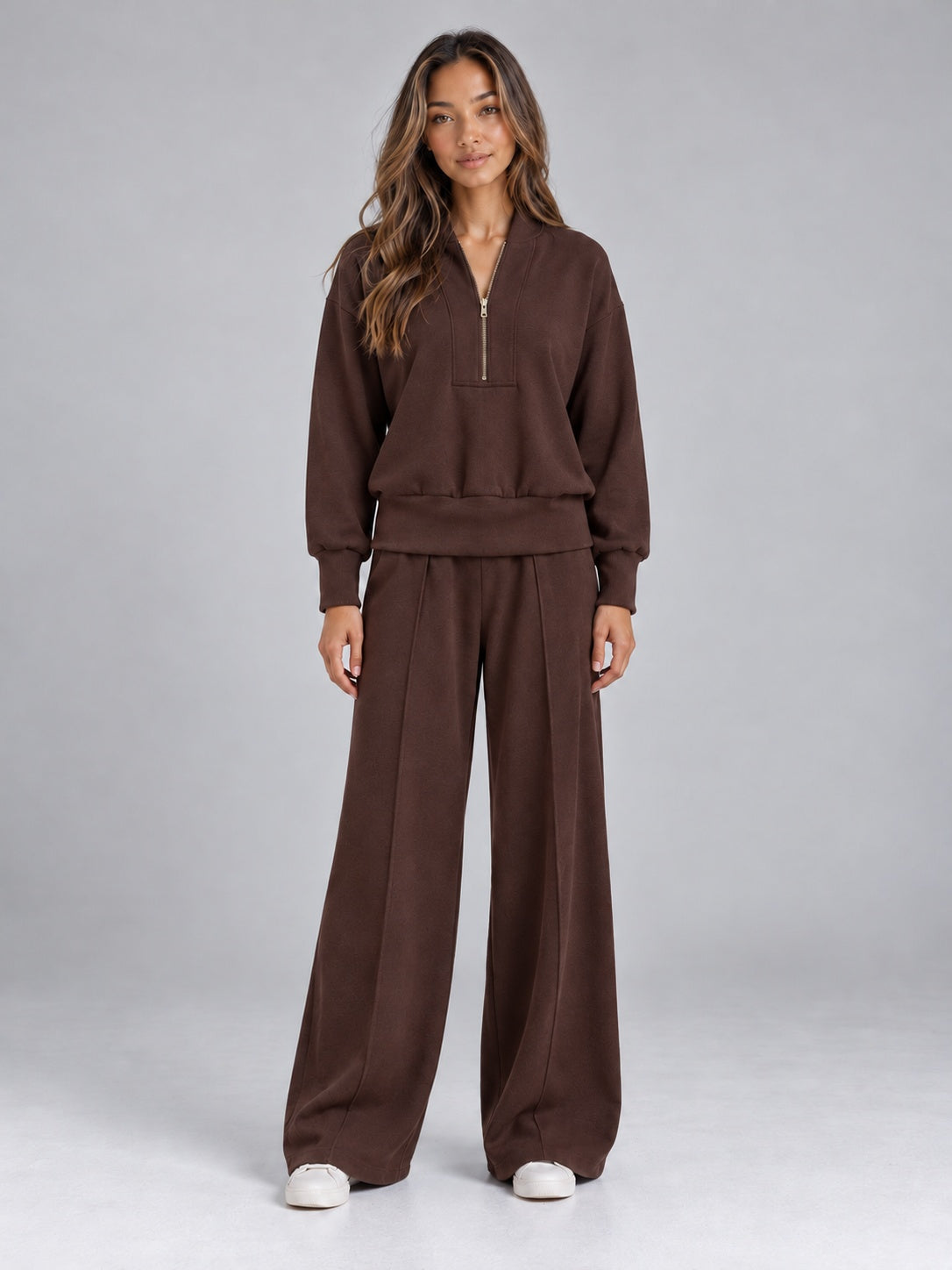 Gebreide tweedelige set met halfzip-trui en wijde broek in bruin, gedragen, vooraanzicht