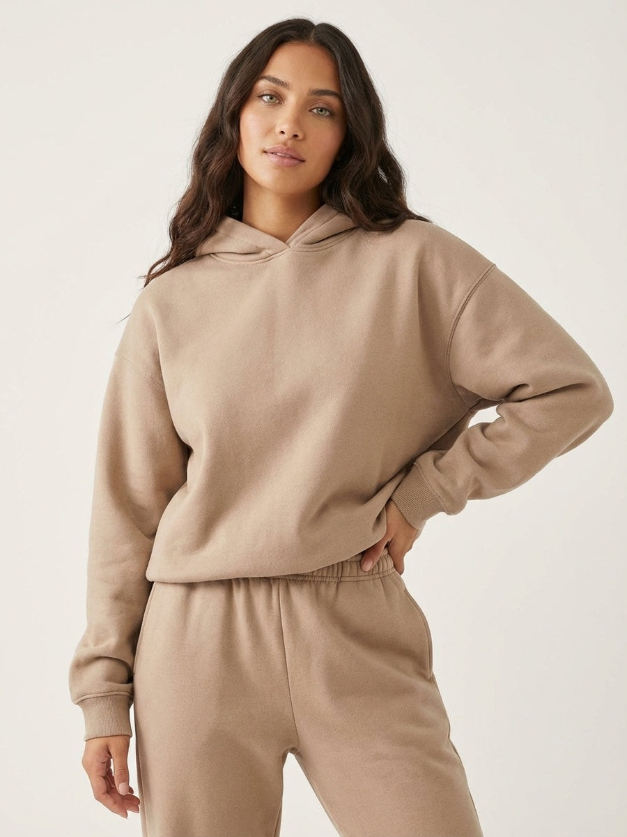 Oversized hoodie en joggingbroek in taupe, hand op de heup