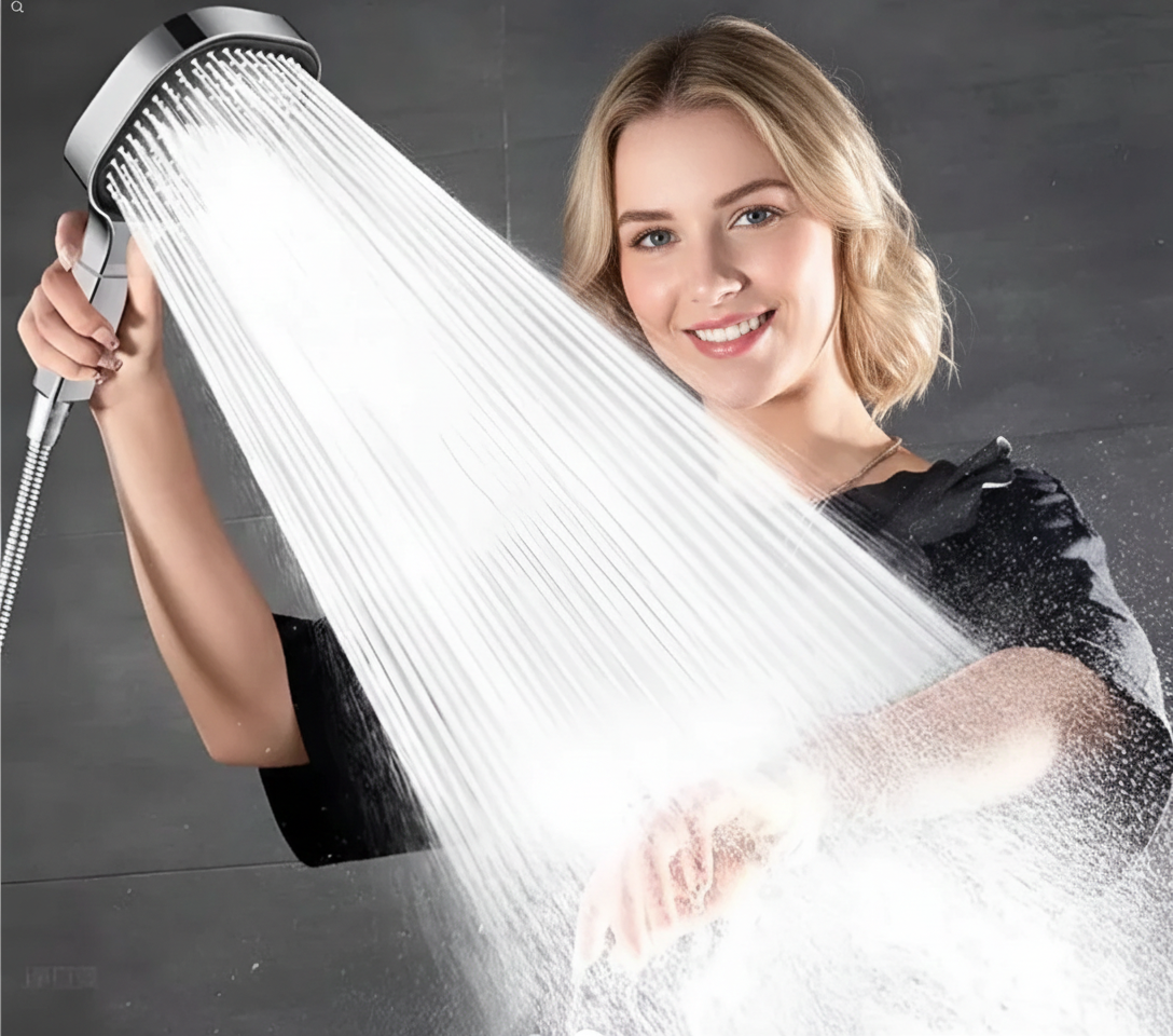 Vrouw houdt zilveren handdouche met sterke waterstraal boven haar arm | Boutique Moda