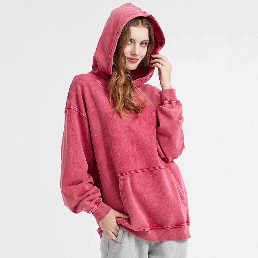 Vrouw in een rode oversized hoodie in vintagelook met de capuchon op en kangoeroezak | Boutique Moda