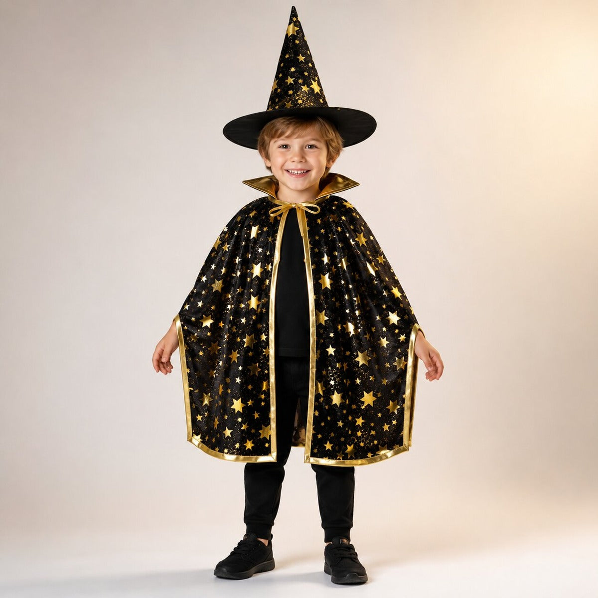 Kind in zwarte cape met gouden sterren en zwarte puntige hoed