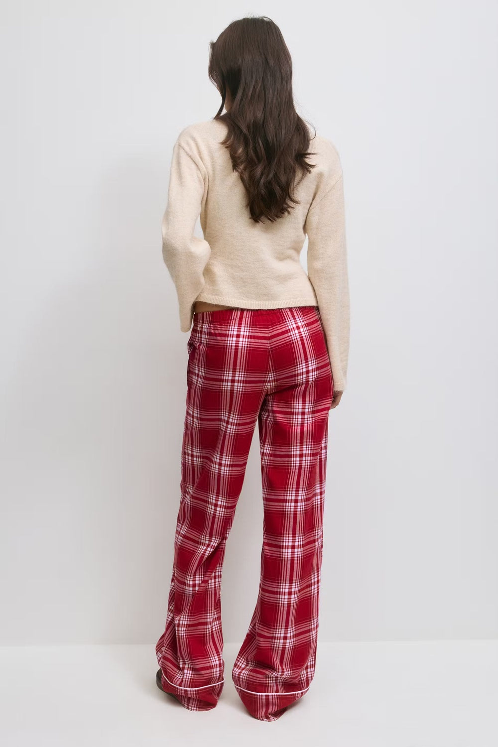 Crèmekleurige trui en rood geruite flanellen pyjamabroek, achteraanzicht