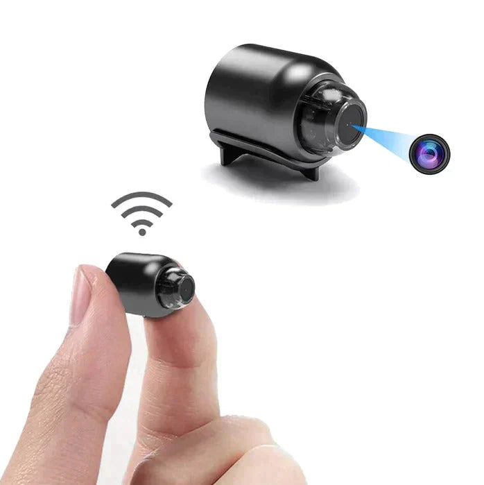 Kleine zwarte WiFi minicamera met lens, vastgehouden tussen vingers | Boutique Moda