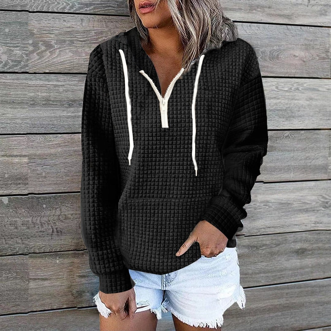 Vrouw in een zwarte hoodie met wafelstructuur en witte koorden, hand in de zak | Boutique Moda