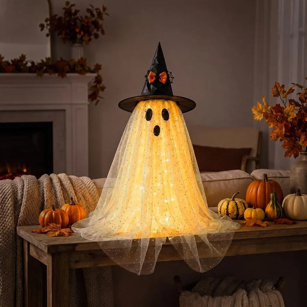 Verlicht spookje met heksenhoed op een tafel in de woonkamer
