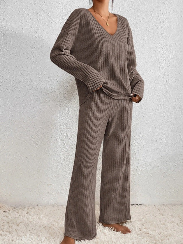 Bruine geribbelde loungewearset met V-hals en wijde broek, gedragen door model | Boutique Moda