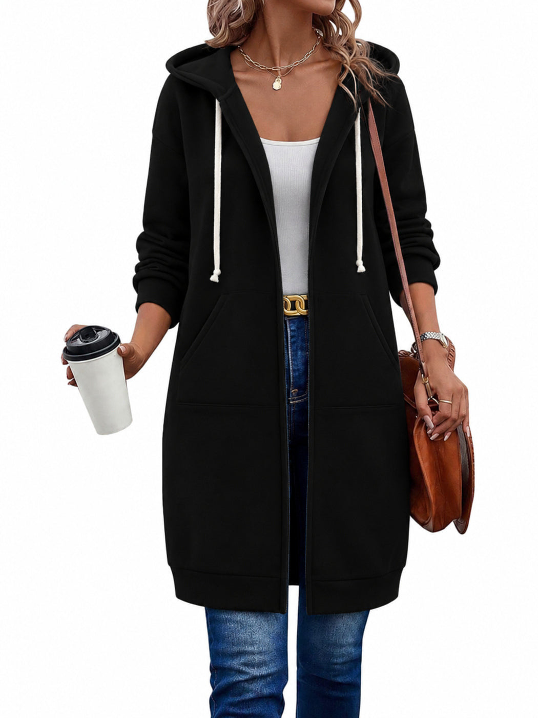 Vrouw in een lang zwart sweatvest, open over een wit topje, met een koffiebeker | Boutique Moda