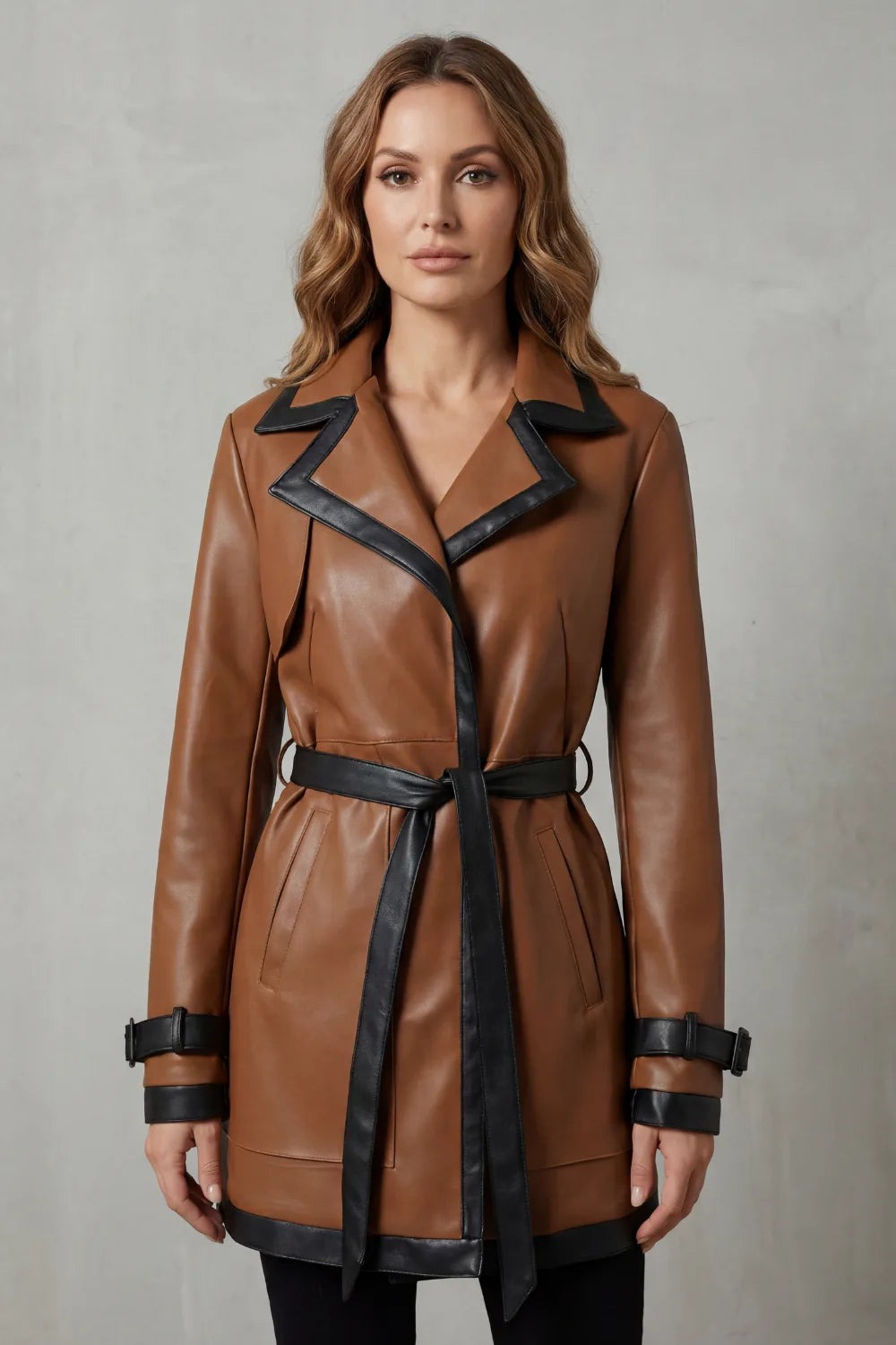 Trenchcoat dames van imitatieleer in bruin met zwarte strikceintuur, gedragen, hele voorkant