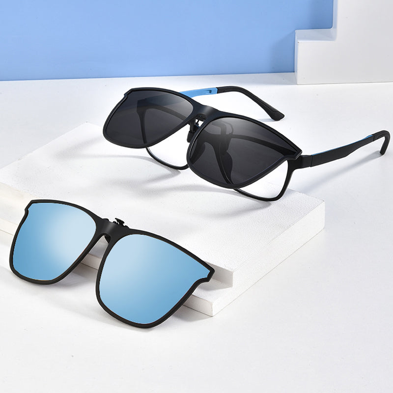 Zwarte opklapbare zonnebril met blauwe spiegelglazen, los liggend op witte kubussen | Boutique Moda