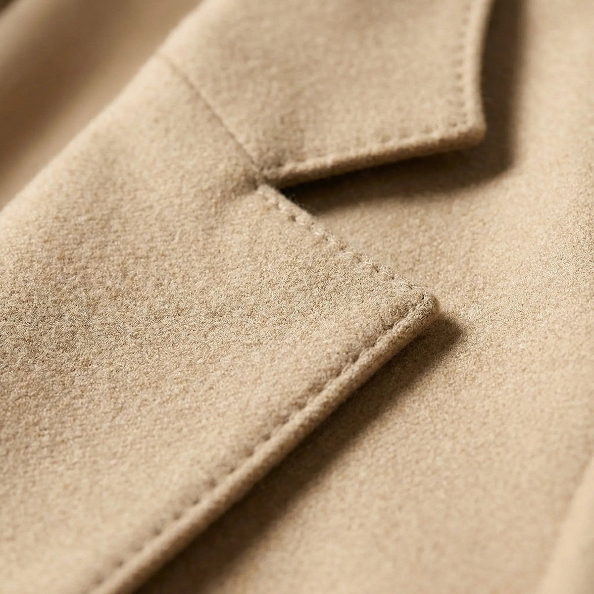 Broekpak met lange blazer en wijde broek in beige, close-up van revers en stof