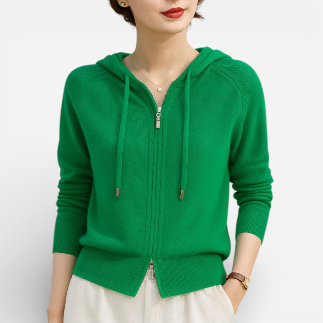 Vrouw draagt een groen gebreid vest met koorden en raglanmouwen, met een lichte broek | Boutique Moda