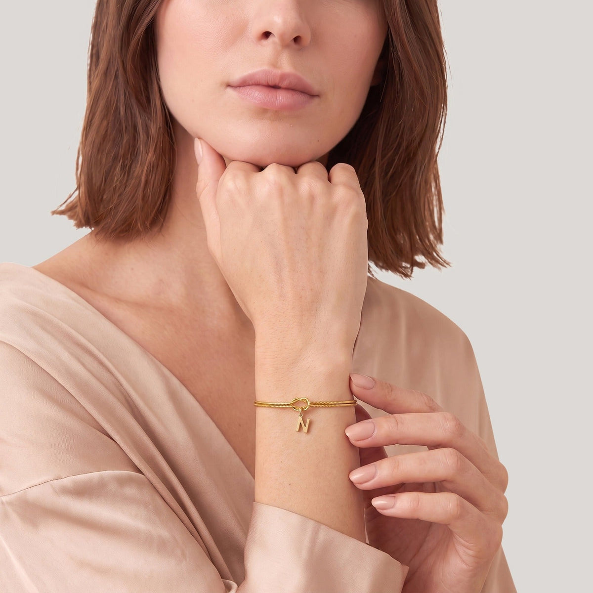 Initiaal armband met knoop om de pols