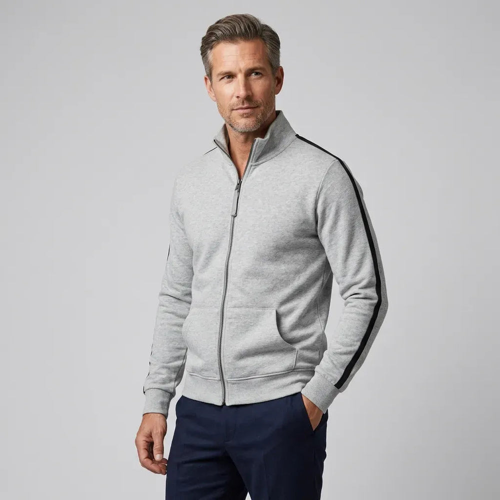 Man in een lichtgrijs sweatvest met zwarte mouwstrepen en een donkerblauwe broek | Boutique Moda