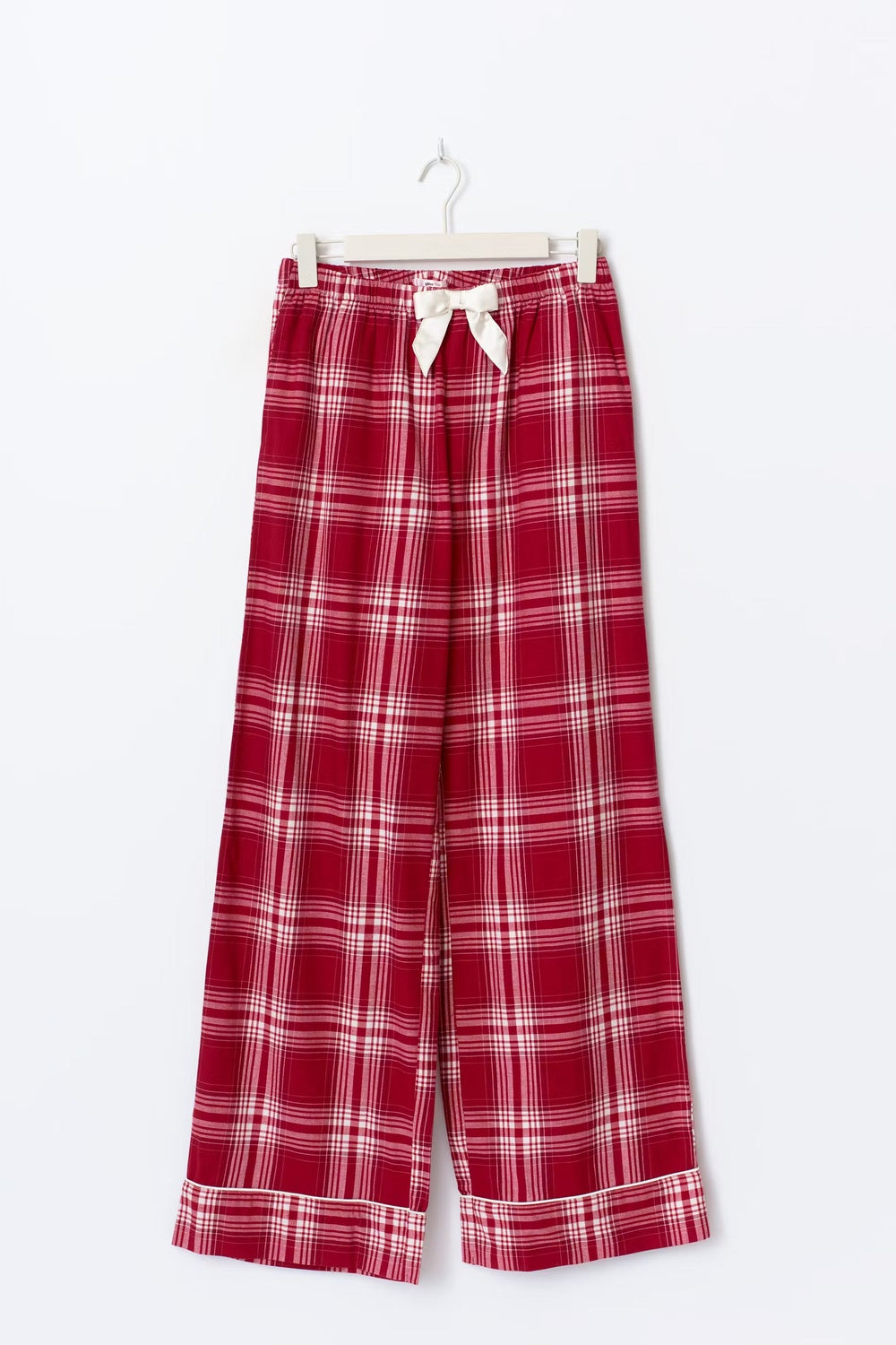 Rood geruite flanellen pyjamabroek met crèmekleurige strik en omgeslagen zomen, aan een hanger