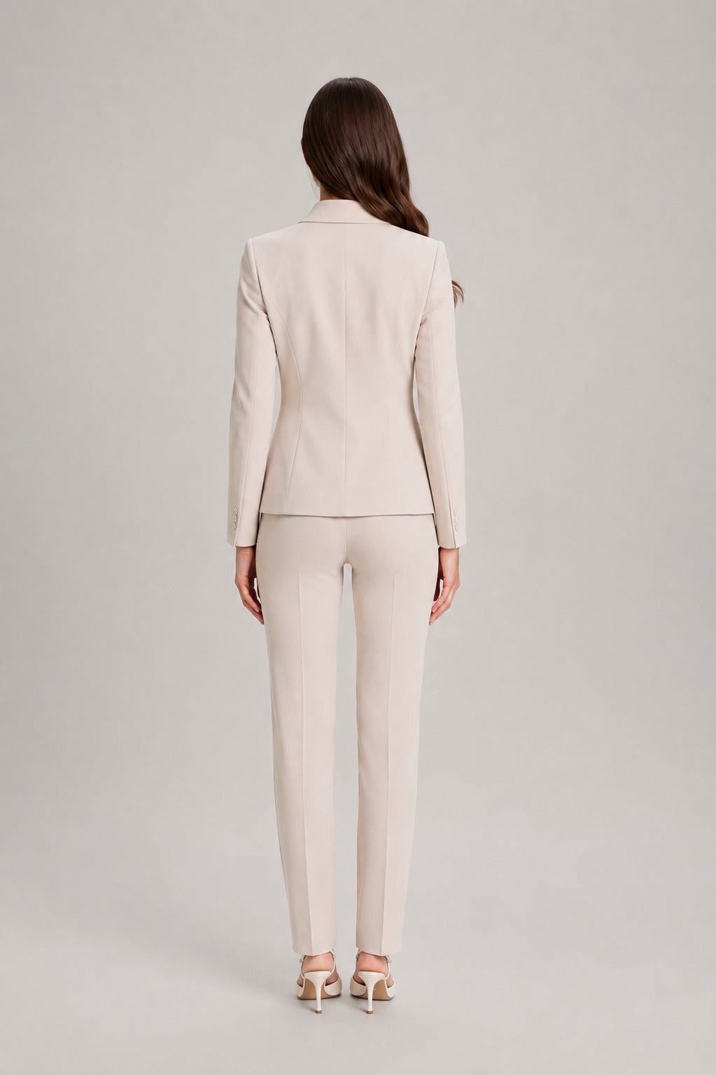Broekpak met asymmetrische wikkelblazer en rechte broek in beige, gedragen, achteraanzicht