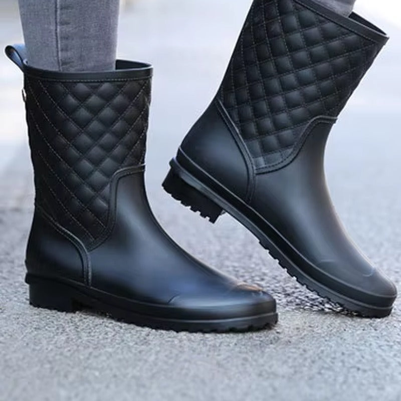 Halfhoge regenlaarzen met gewatteerde look in zwart, gedragen op straat