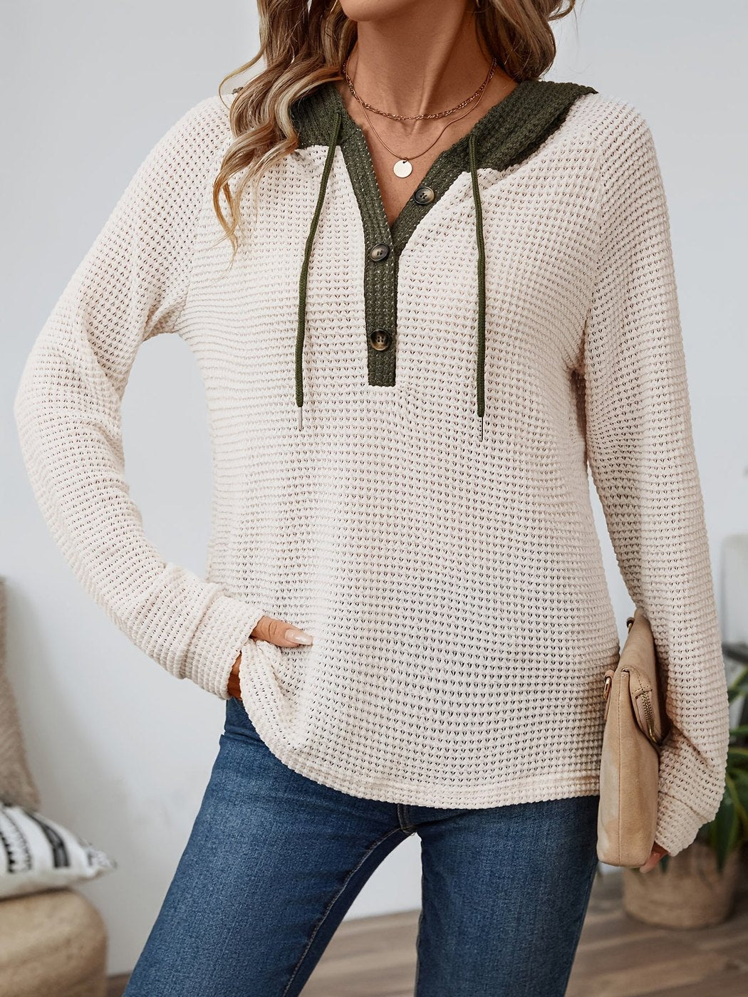 Vrouw in een wafelhoodie in Beige/Olijfgroen met koorden, met een tas onder de arm | Boutique Moda