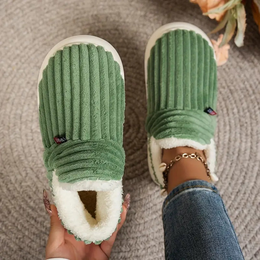 Groene slof met teddyvoering in de hand