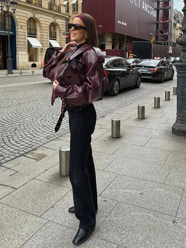 Kort jasje van imitatieleer voor dames in bordeaux met een brede reverskraag, gedragen, ten voeten uit van opzij