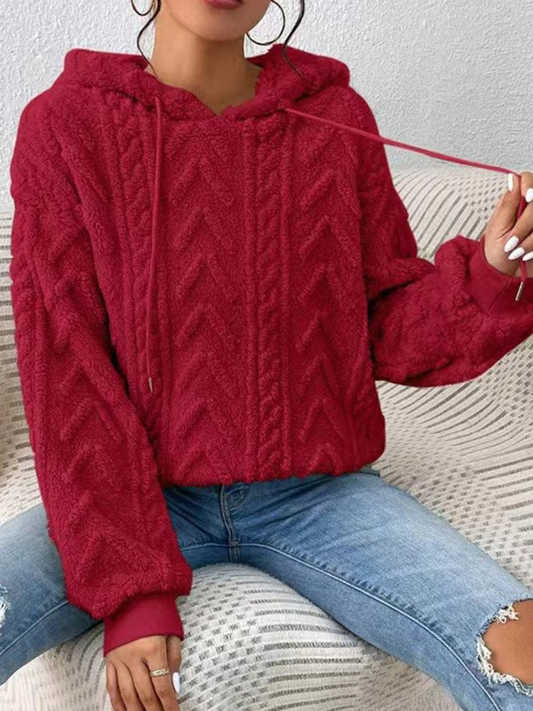 Vrouw in een rode teddytrui trekt aan een koord van de capuchon | Boutique Moda