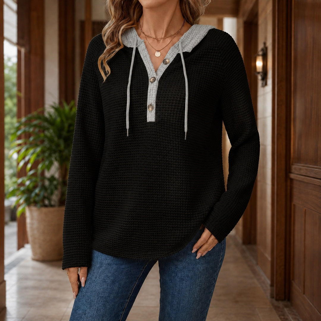 Vrouw in zwarte wafeltrui met lichtgrijze capuchon en een jeans | Boutique Moda