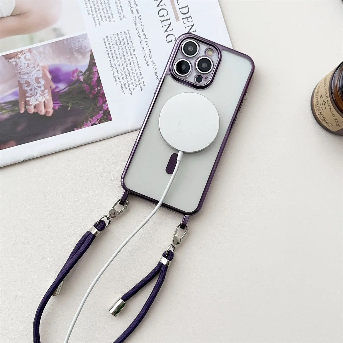 Paars transparant telefoonhoesje met koord en magnetische ring, plat liggend naast tijdschrift | Boutique Moda