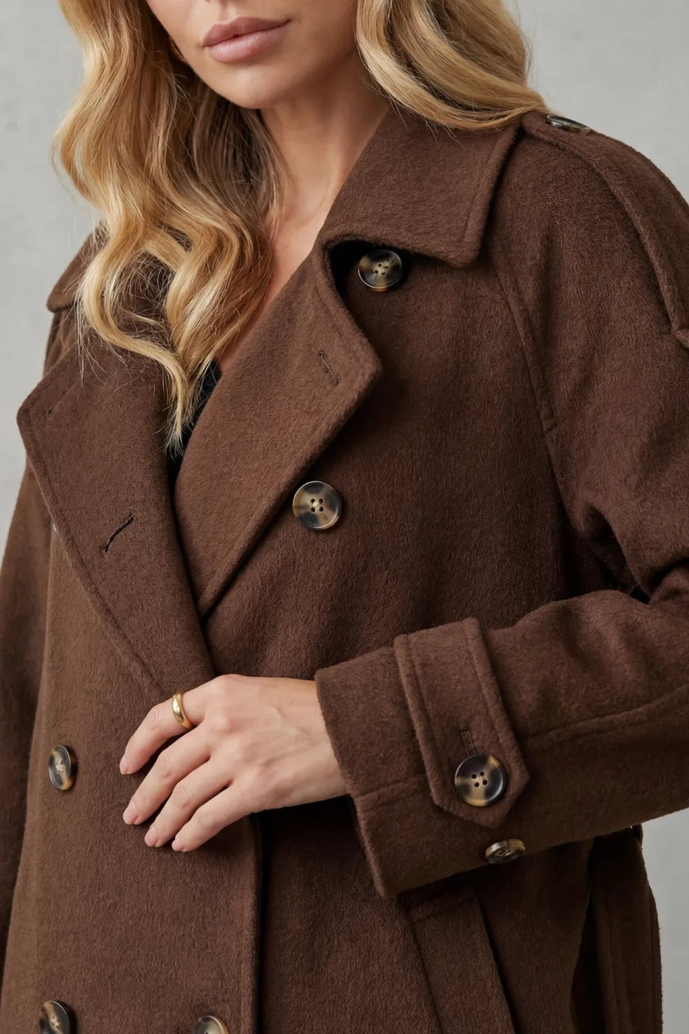 Oversized wollen trenchcoat in bruin, close-up van de kraag en knopen