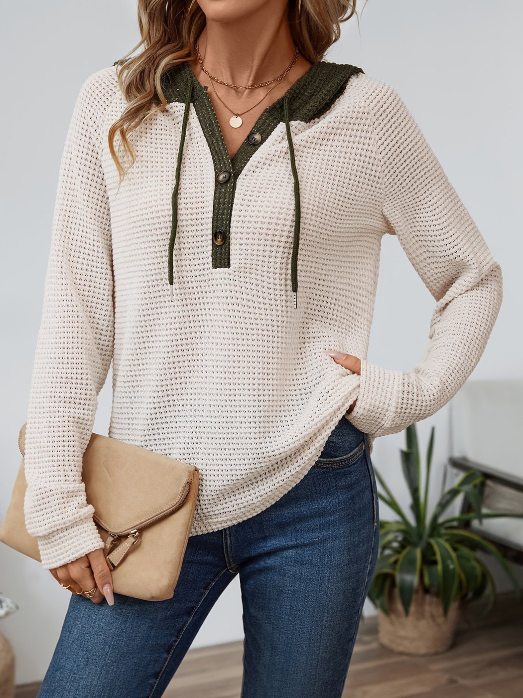 Vrouw in een wafelhoodie in Beige/Olijfgroen met contrastcapuchon, hand op de heup | Boutique Moda