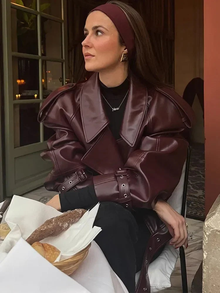 Kort jasje van imitatieleer voor dames in bordeaux, close-up van de kraag en het gespbandje aan de mouw