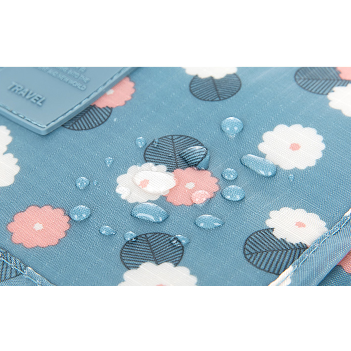 Blauwe waterafstotende toilettas met bloemenprint en waterdruppels, plat close-up getoond | Boutique Moda