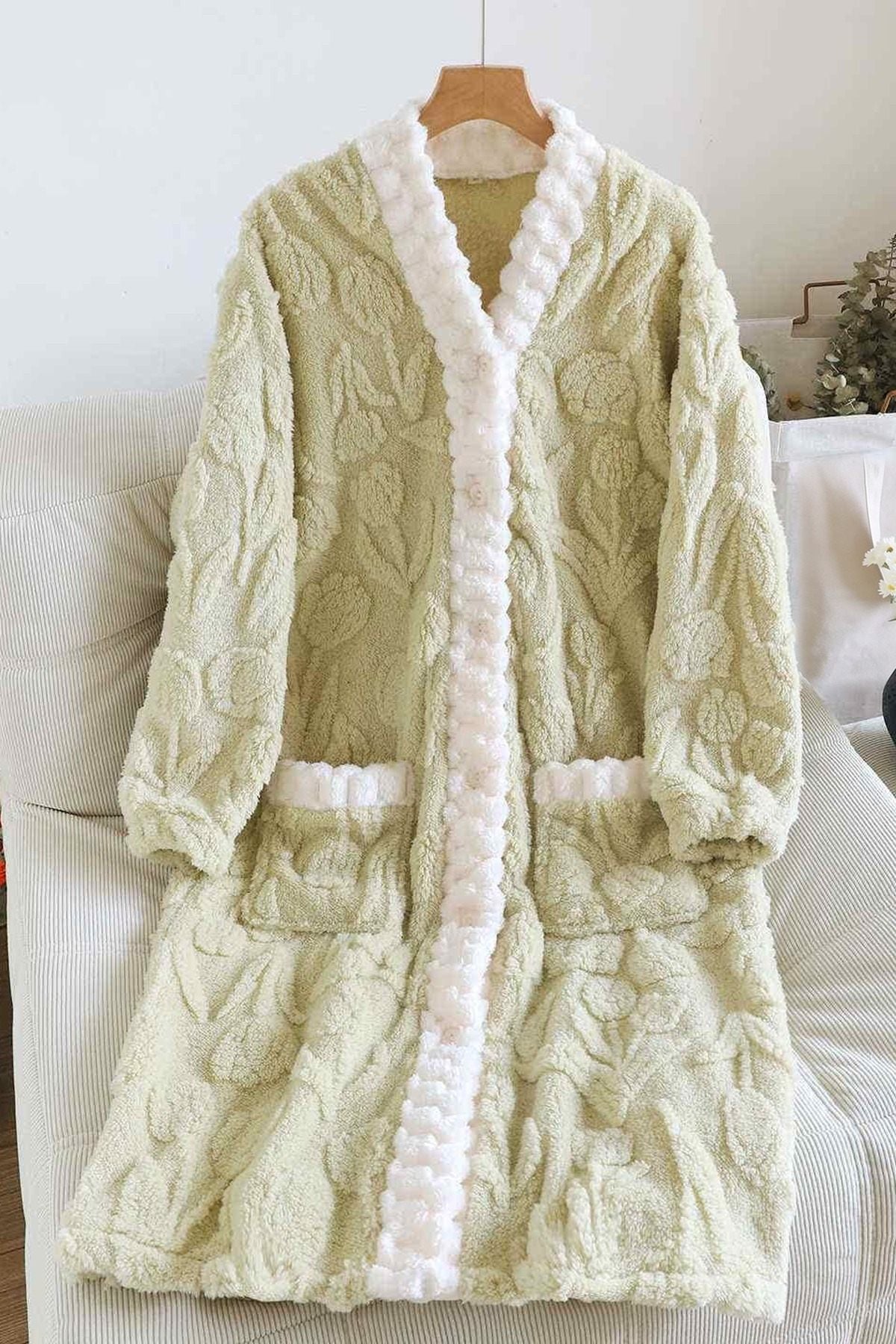 Saliegroen fleece nachthemd met opgestikte zakken aan een hanger