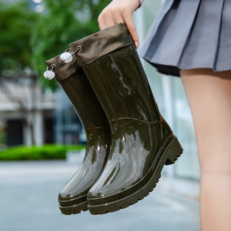 Regenlaarzen met stoffen schacht en koord in olijfgroen, in de hand gehouden