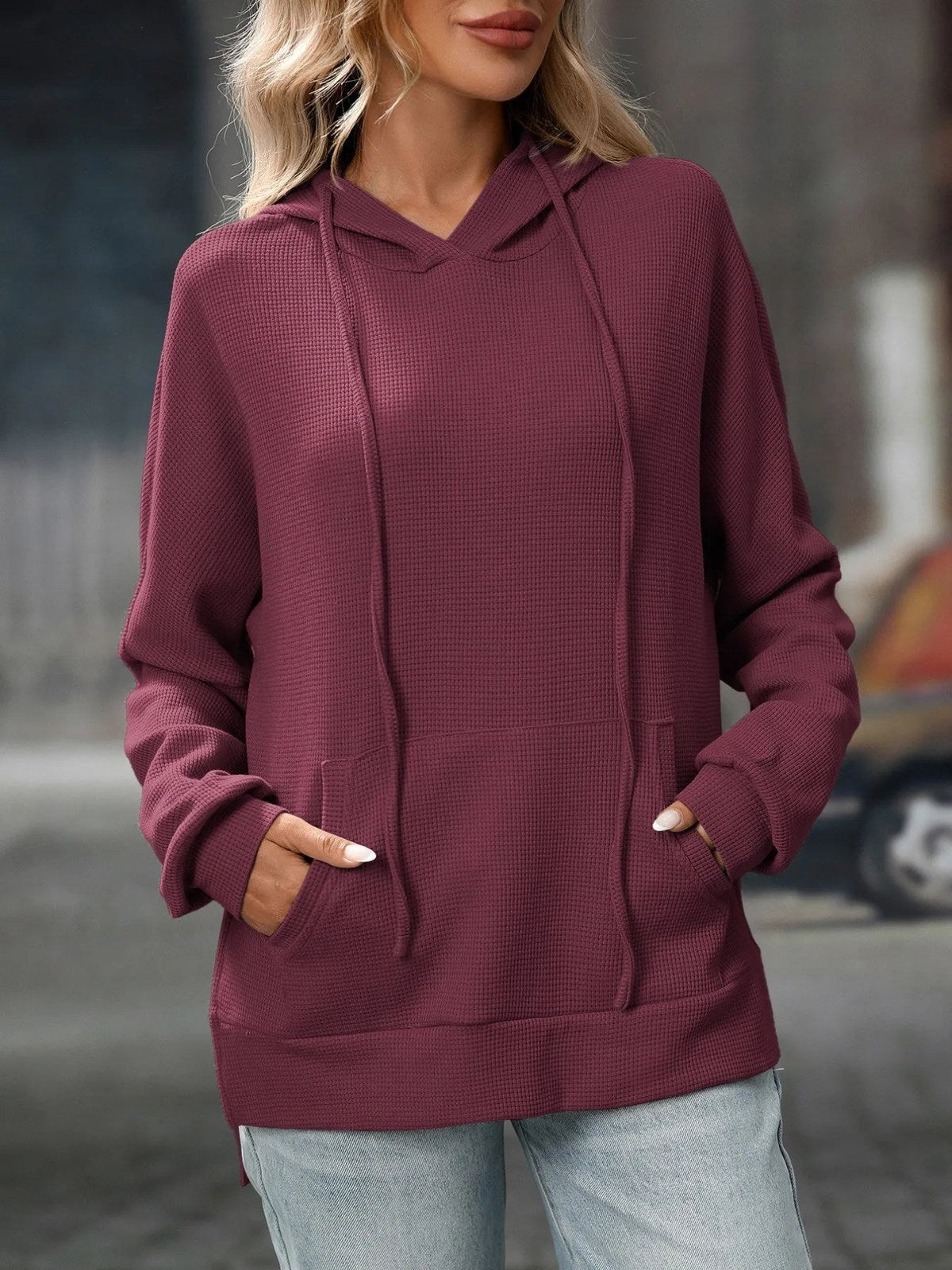 Bordeaux sweater met capuchon en lange koorden, gedragen met lichte jeans | Boutique Moda