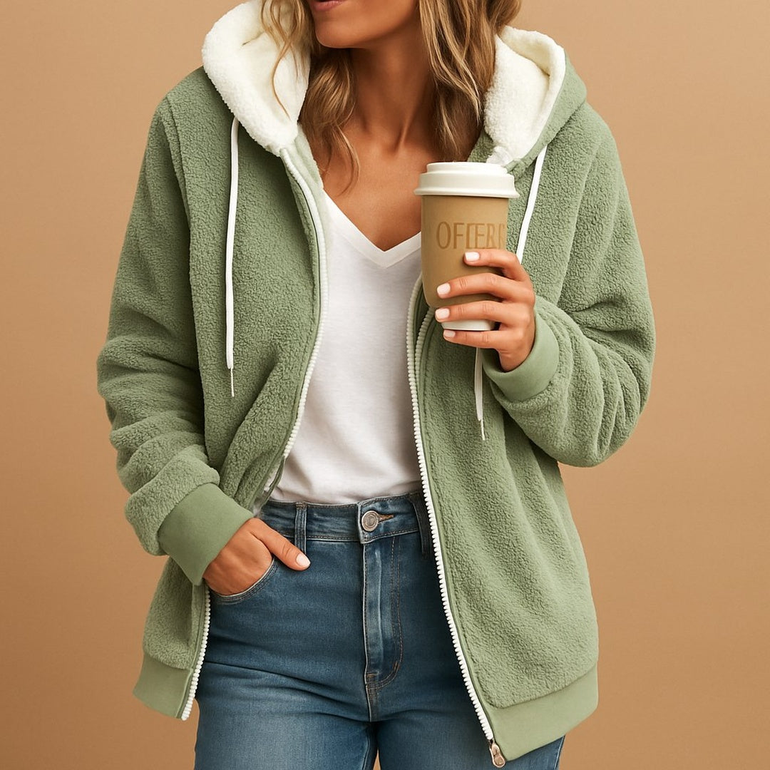 Vrouw draagt saliegroene teddyjas met crèmekleurige capuchon, met koffiebeker | Boutique Moda